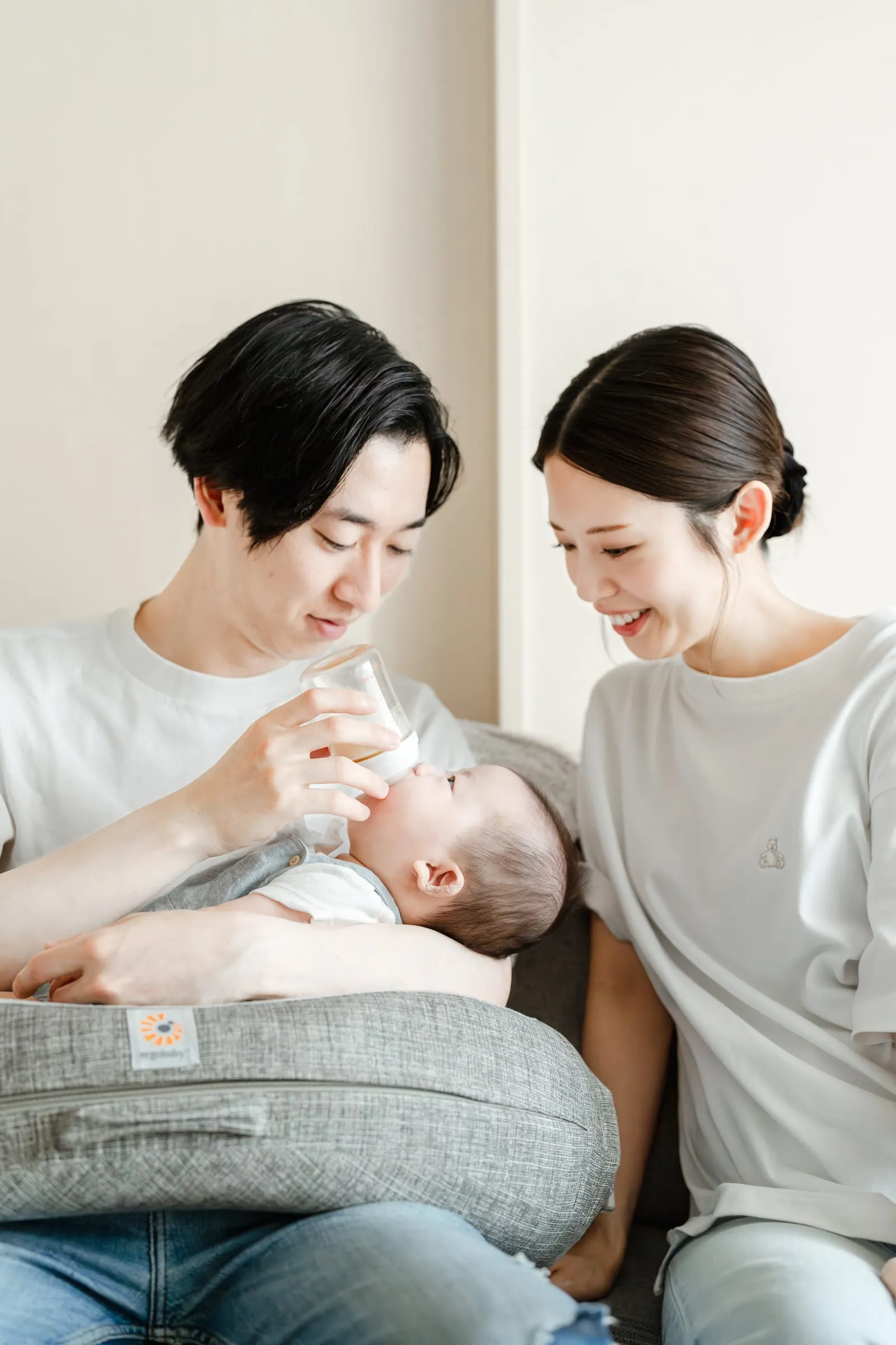 窓辺で赤ちゃんを抱きしめる母